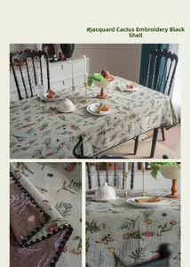 Detailed view of French vintage floral jacquard tablecloth with black shell-edge embroidery