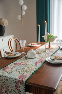 Detailed close-up of a floral table runner with green pom-pom trim in French country style