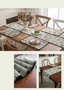Close-up of pastoral floral jacquard table runner and placemats with black wavy edges