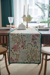 Detail showing vintage floral jacquard pattern and dark green crochet lace edge on table runner