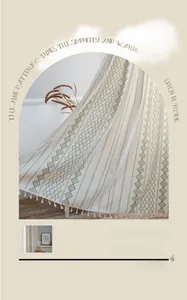 Détail du rideau nordique avec motifs géométriques verts et pompons en coton