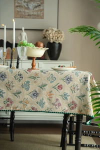 Detailed jacquard weave tablecloth with floral patterns and dark green scalloped edges