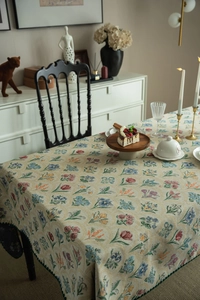 Close-up of vintage floral jacquard tablecloth with scalloped green edges and fine texture