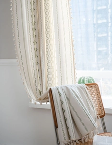 Vue détaillée du rideau en lin bohème avec broderie géométrique verte et bordure à glands