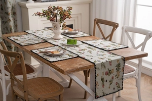 Detail of floral jacquard table runner and placemats with black pom-pom lace trim