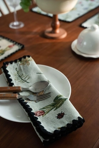 Detailed close-up of pastoral floral jacquard table runner with tulip patterns and lace edges