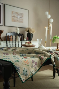 Close-up of jacquard tablecloth featuring floral patterns and green scalloped edges