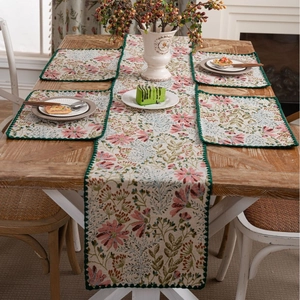 Floral pink lily embroidered table runner set with green crochet lace on wooden table