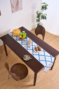 Blue geometric Moroccan print table runner on dark wood surface with elegant home decor