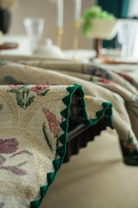 Detailed close-up of French floral jacquard tablecloth with green crochet lace edge