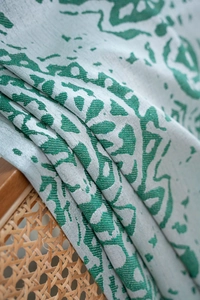 Macro shot of green and white jacquard fabric texture with woven teardrop pattern detail