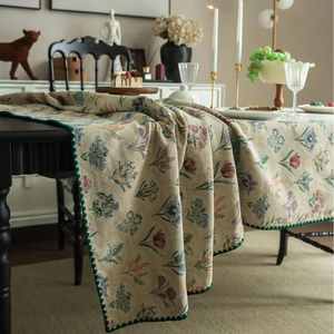 French vintage floral jacquard tablecloth in beige with colorful patterns on dining table