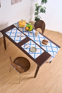 Blue geometric print table runner and placemats on dark wooden dining table