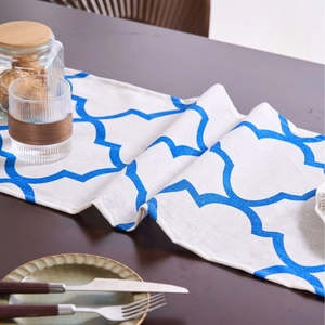Blue geometric clover floral table runner on wooden desk with home accessories
