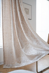 Detailed close-up of khaki jacquard curtains with elegant paisley patterns in a living room