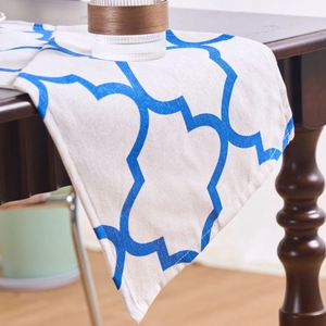 Blue clover pattern table runner made of thick linen fabric on a dark wood table