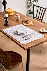 Close-up of modern gray wheat print napkin on wooden table with elegant dining set