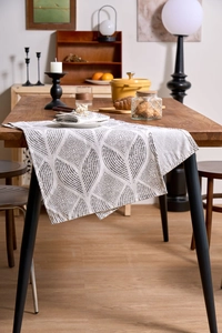 Detail of grey geometric leaf print napkins and runner on wooden table setting