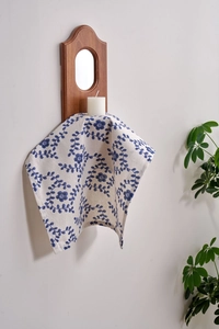 Detail of French floral vine print cotton linen napkins hanging on a wooden wall rack