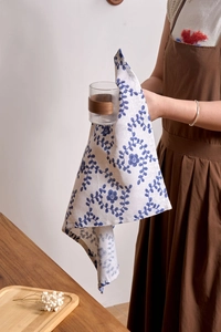 Detailed texture of cotton linen napkin with blue vine floral print on white background