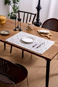 Detail of Nordic fabric napkin with lemon floral prints on a rustic wooden dining table