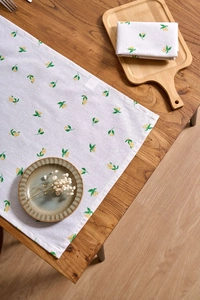 Close-up of Nordic fabric napkin with vibrant lemon prints on a rustic wooden table