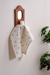 Detail of linen napkin featuring fresh lemon print hanging in a home setting