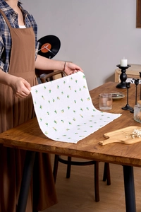 Detail of linen-textured fabric napkin with lemon patterns on a rustic wooden table