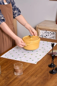 Close-up of a bright yellow enameled cast iron Dutch oven with stainless steel handle lid