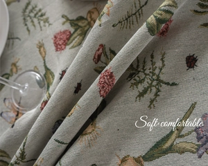 Detailed close-up of French vintage jacquard tablecloth with floral and insect embroidery