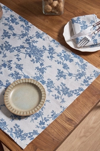 Close-up of European floral napkin featuring blue roses on linen fabric for table decor