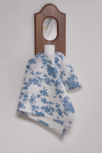 Detail of vintage blue rose pattern on cream linen napkin with a white care label