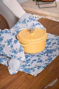 Classic yellow enamel dutch oven on blue floral napkin cloth for kitchen table decor