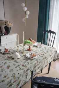 Detail of French vintage floral jacquard tablecloth with pom-pom fringe in bean green
