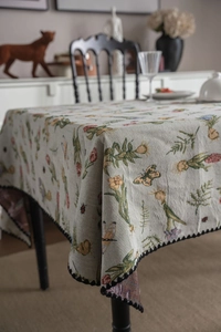 Detailed close-up of French vintage floral jacquard tablecloth with black lace edges