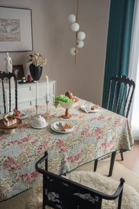 Detail of French vintage floral tablecloth featuring intricate jacquard and scalloped green edges
