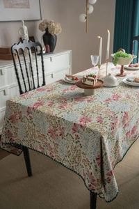 Detail of French vintage floral tablecloth with intricate jacquard weave and green wavy edges