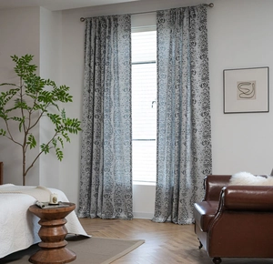 Detail of grey-blue damask curtains with teardrop jacquard pattern in a modern living room