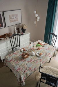 Close-up of French vintage floral tablecloth with green scalloped edges and jacquard texture