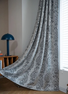 Detail of grey damascus pattern curtains with textured jacquard fabric and elegant drape