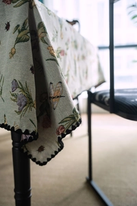 Macro detail of French vintage floral jacquard tablecloth with zigzag lace border
