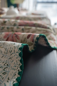 Close-up of French vintage floral embroidery with green scalloped crochet lace edges
