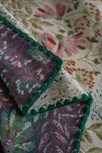 Close-up of French vintage embroidered tablecloth with green crochet serrated edges