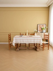 Detail of cream rectangular tablecloth with red stripes and white fringe tassels