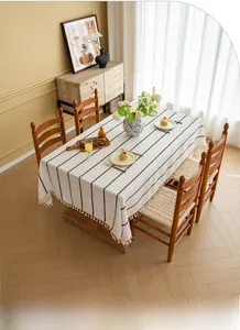 Detail of minimalist tablecloth featuring black vertical stripes and fringe tassels
