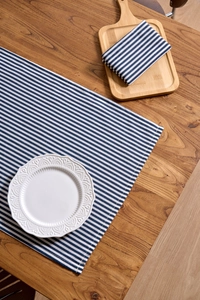Close-up of blue and white striped Japanese cotton napkin on a wooden dinner table