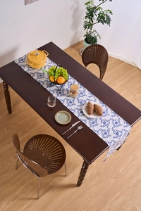 Close-up of blue floral table runner on dark wood table in a warm dining scene