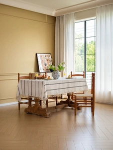 Detail of cream linen tablecloth with black striped embroidery and elegant tassels