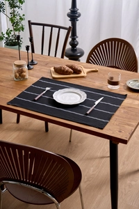 Close-up of black and white striped linen napkin on a wooden table with tableware