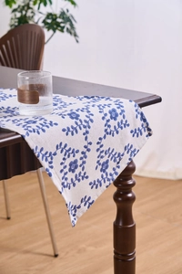 Detail of floral printed linen table runner on dark wood with natural fabric texture